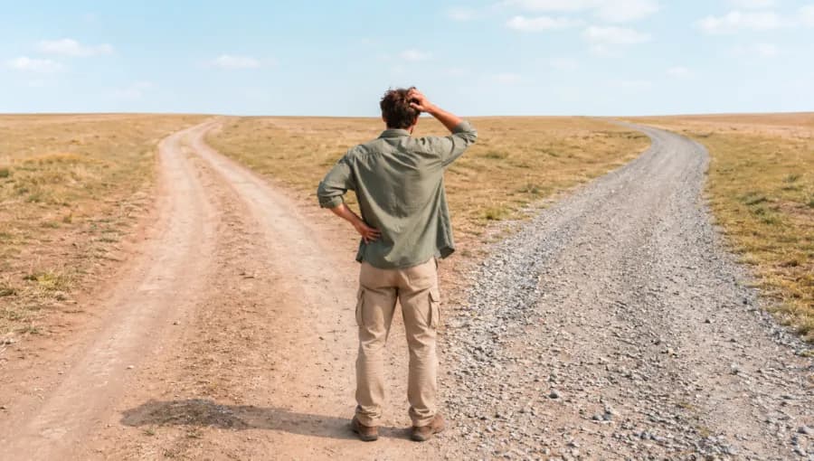 Homme à la croisée de deux chemins, regardant l’horizon